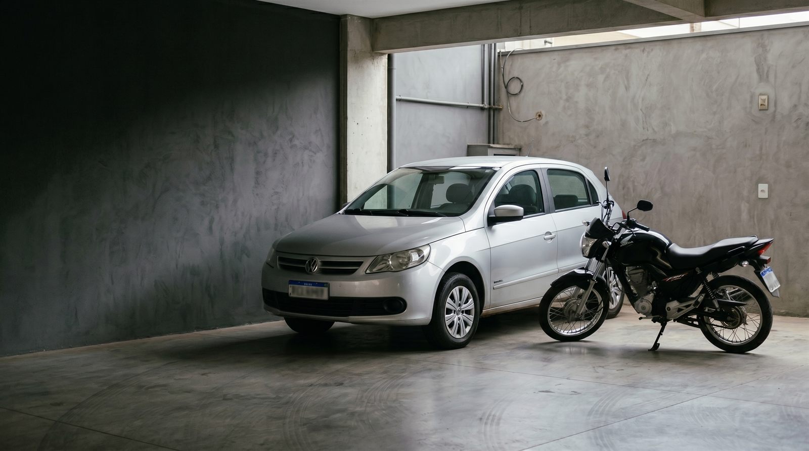 Carro e moto usados em garagem urbana
